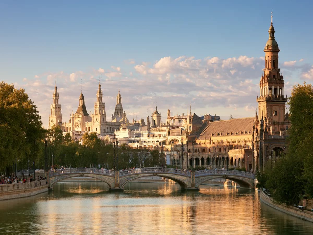 A sunlit river and ornate towers of a European city